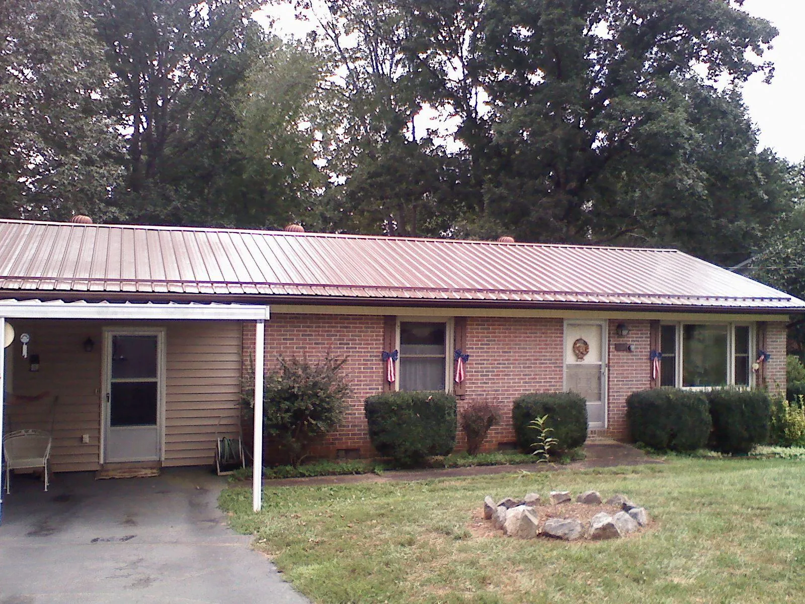 Bronze metal roof and carport on a brick ranch home — Roof Repair work by our crew in Midlothian